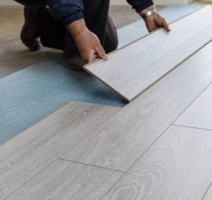 Worker installing laminate flooring