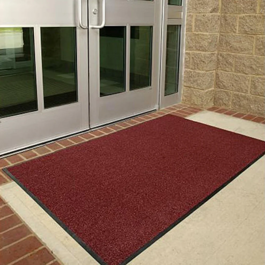 A red doormat on a brick floor